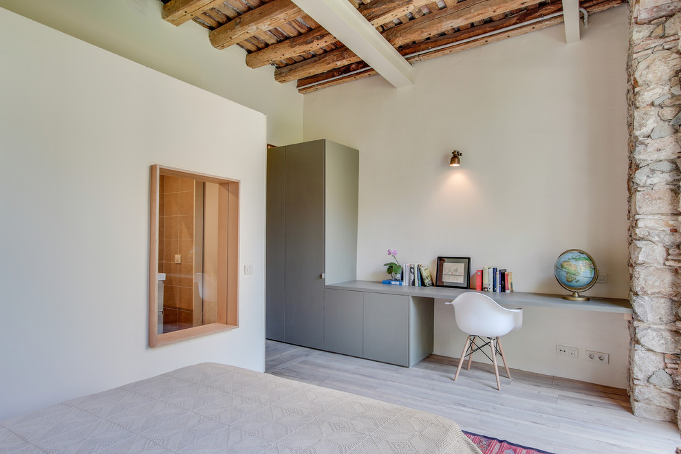 Mittelgroßes Mediterranes Arbeitszimmer ohne Kamin mit Arbeitsplatz, weißer Wandfarbe, Einbau-Schreibtisch und hellem Holzboden in Sonstige