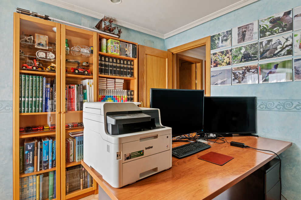Example of a mid-sized transitional freestanding desk medium tone wood floor and brown floor study room design in Madrid with blue walls