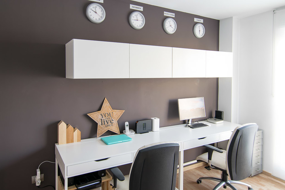 Esempio di un ufficio nordico di medie dimensioni con pareti nere, pavimento in laminato e scrivania autoportante