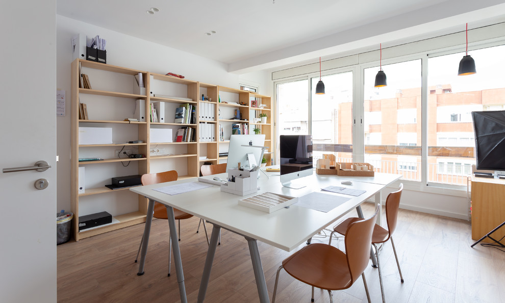 Esempio di un grande ufficio scandinavo con pareti bianche, pavimento in legno massello medio, nessun camino, scrivania autoportante e pavimento marrone