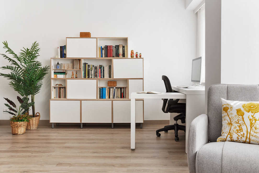 Modelo de despacho minimalista de tamaño medio con paredes blancas, suelo laminado, escritorio independiente y suelo beige