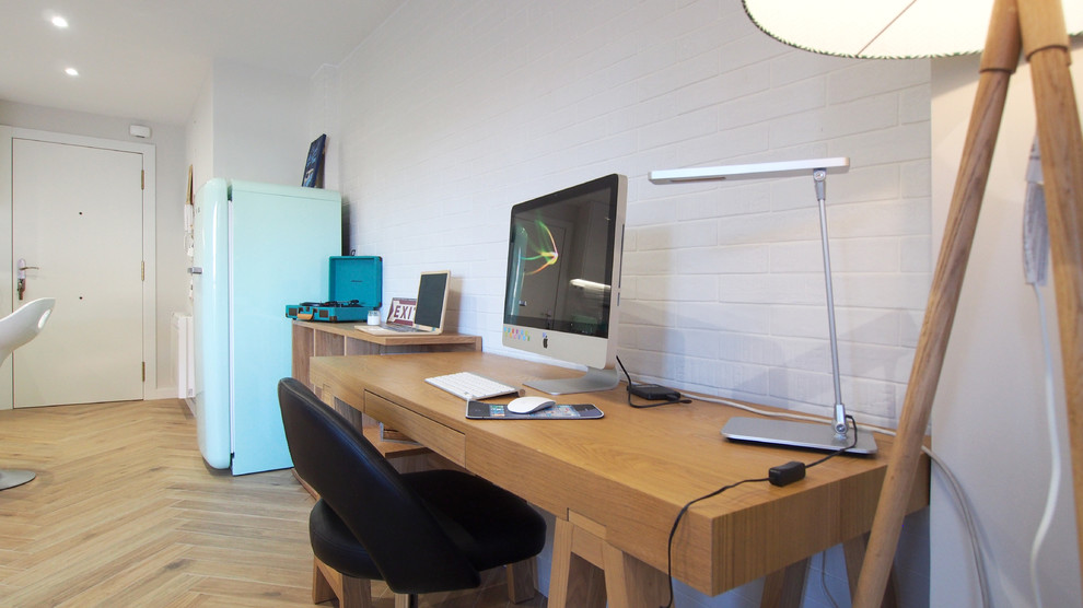 This is an example of a small scandinavian home studio in Other with white walls, light hardwood flooring, a freestanding desk and brown floors.