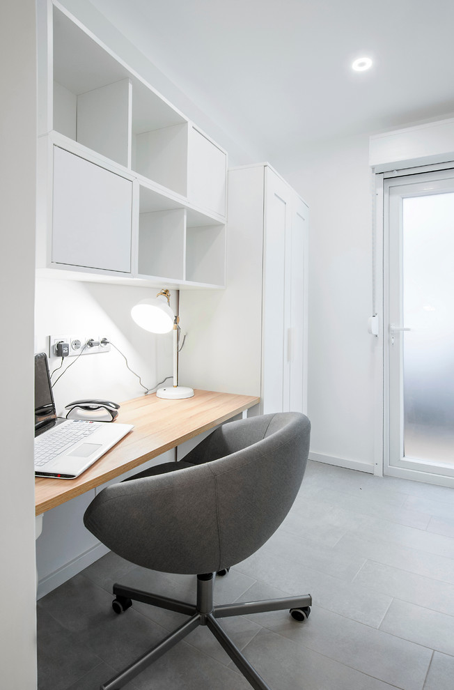 Kleines Nordisches Arbeitszimmer mit Arbeitsplatz, weißer Wandfarbe, Keramikboden und Einbau-Schreibtisch in Sonstige