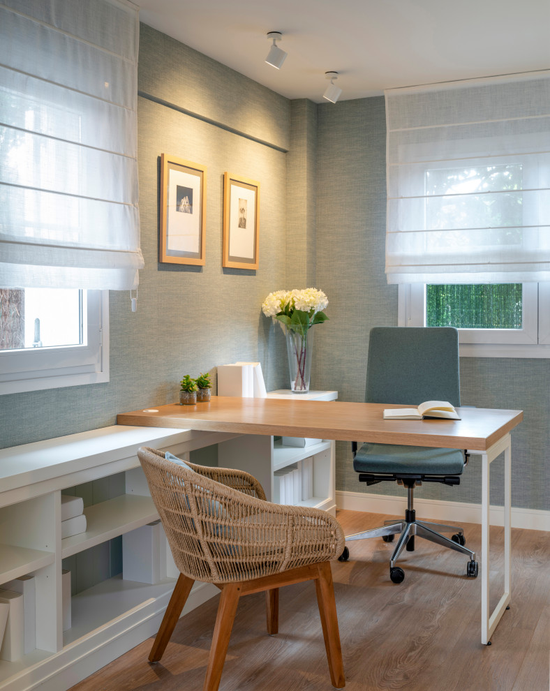 Ejemplo de despacho clásico renovado grande sin chimenea con paredes azules, suelo laminado, escritorio independiente y suelo marrón