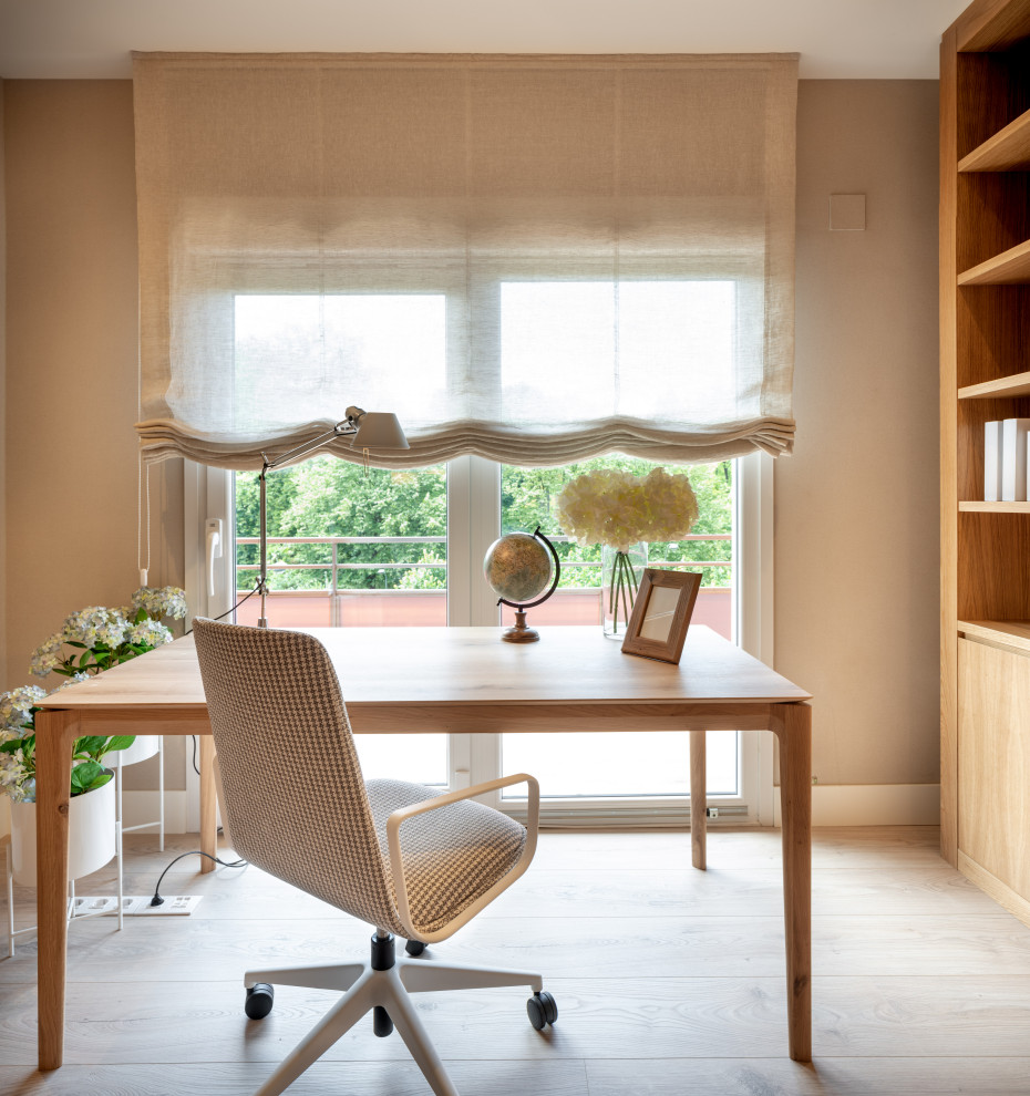 Mittelgroßes Klassisches Arbeitszimmer ohne Kamin mit Studio, beiger Wandfarbe, Laminat, freistehendem Schreibtisch, braunem Boden und Tapetenwänden in Bilbao