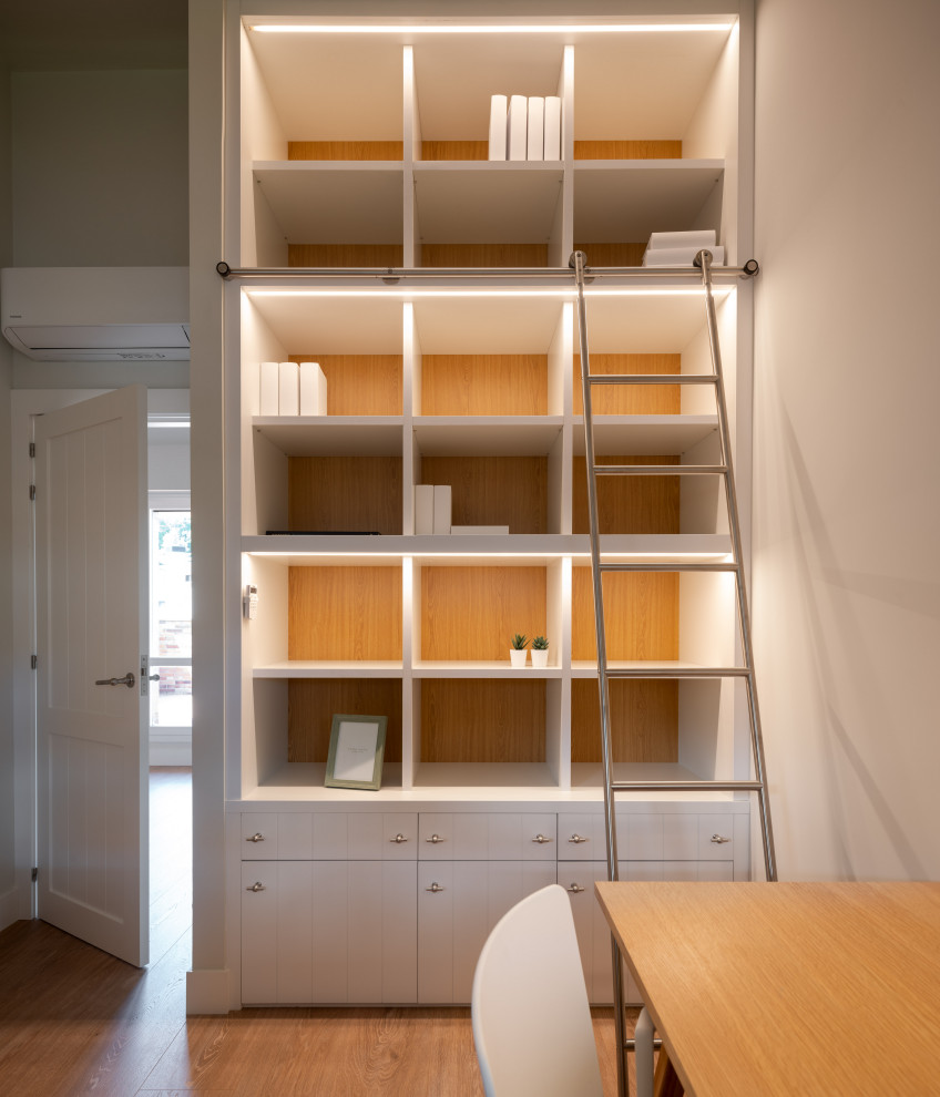 Cette photo montre un bureau chic de taille moyenne avec une bibliothèque ou un coin lecture, un mur beige, sol en stratifié, aucune cheminée, un bureau indépendant et un sol beige.