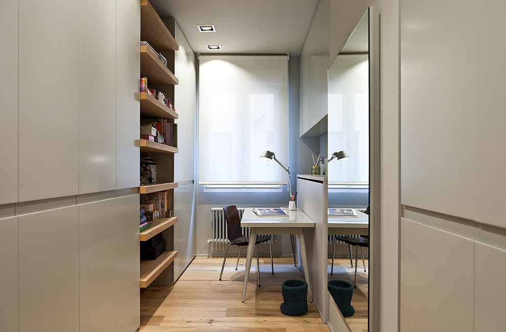 Imagen de despacho clásico renovado pequeño sin chimenea con paredes grises, suelo de madera clara y escritorio independiente