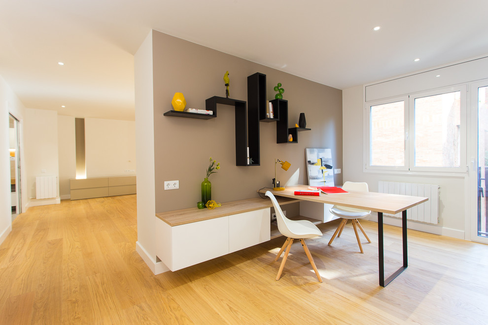 Cette photo montre un bureau tendance de taille moyenne avec un mur multicolore, un sol en bois brun, aucune cheminée et un bureau intégré.