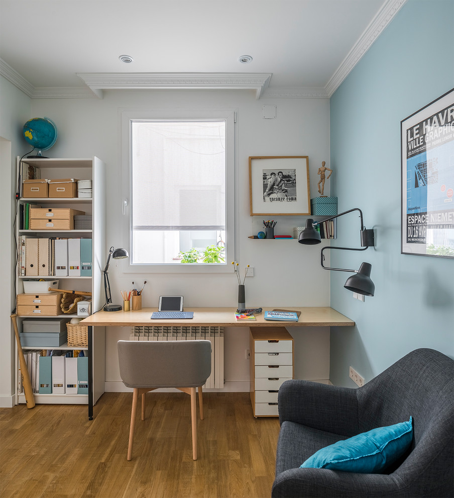 マドリードにあるコンテンポラリースタイルのおしゃれなホームオフィス・書斎 (青い壁、無垢フローリング、造り付け机、茶色い床) の写真