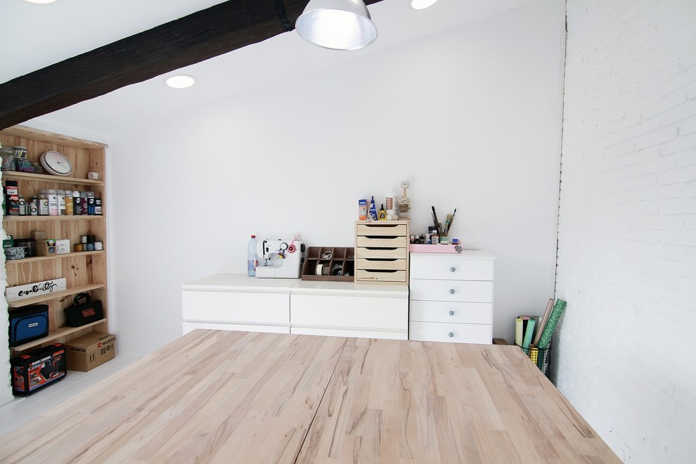 Modelo de estudio nórdico de tamaño medio con paredes blancas, suelo de madera clara y escritorio independiente
