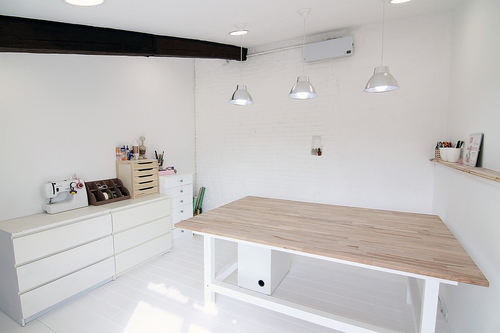 Modelo de estudio nórdico de tamaño medio con paredes blancas, suelo de madera clara y escritorio independiente