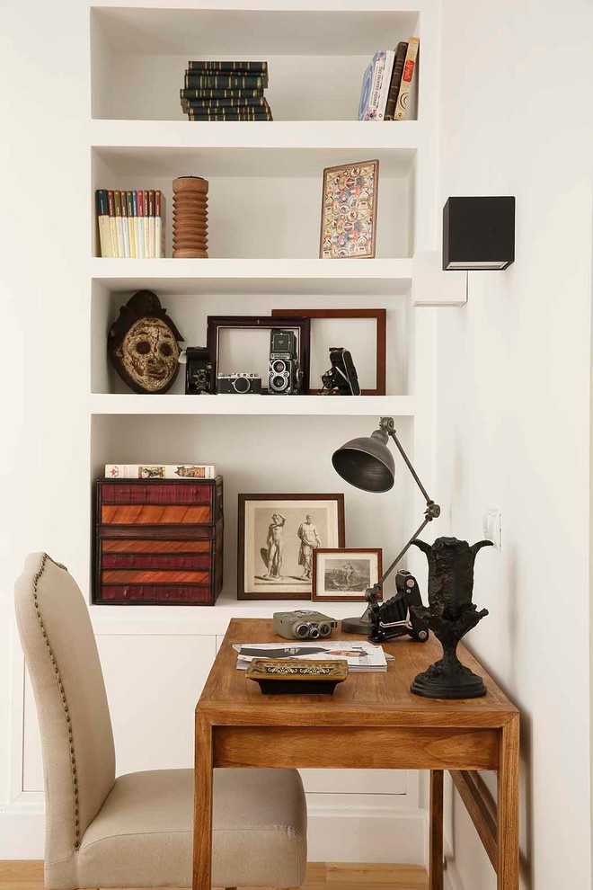 Ejemplo de despacho tradicional con paredes blancas y escritorio independiente