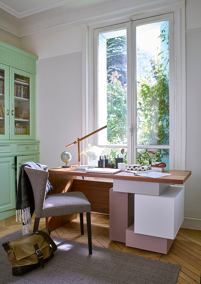 Mittelgroßes Klassisches Arbeitszimmer mit Studio, weißer Wandfarbe, braunem Holzboden und freistehendem Schreibtisch in Madrid