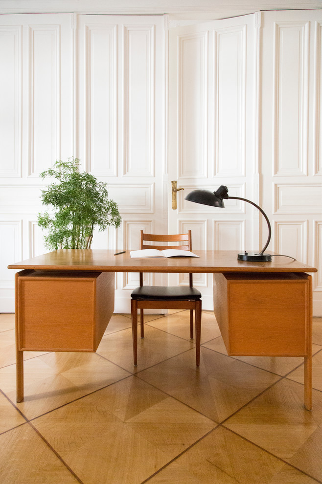 Cette image montre un grand bureau design avec un mur blanc, un sol en bois brun, une cheminée standard, un manteau de cheminée en pierre, un bureau indépendant et un sol marron.