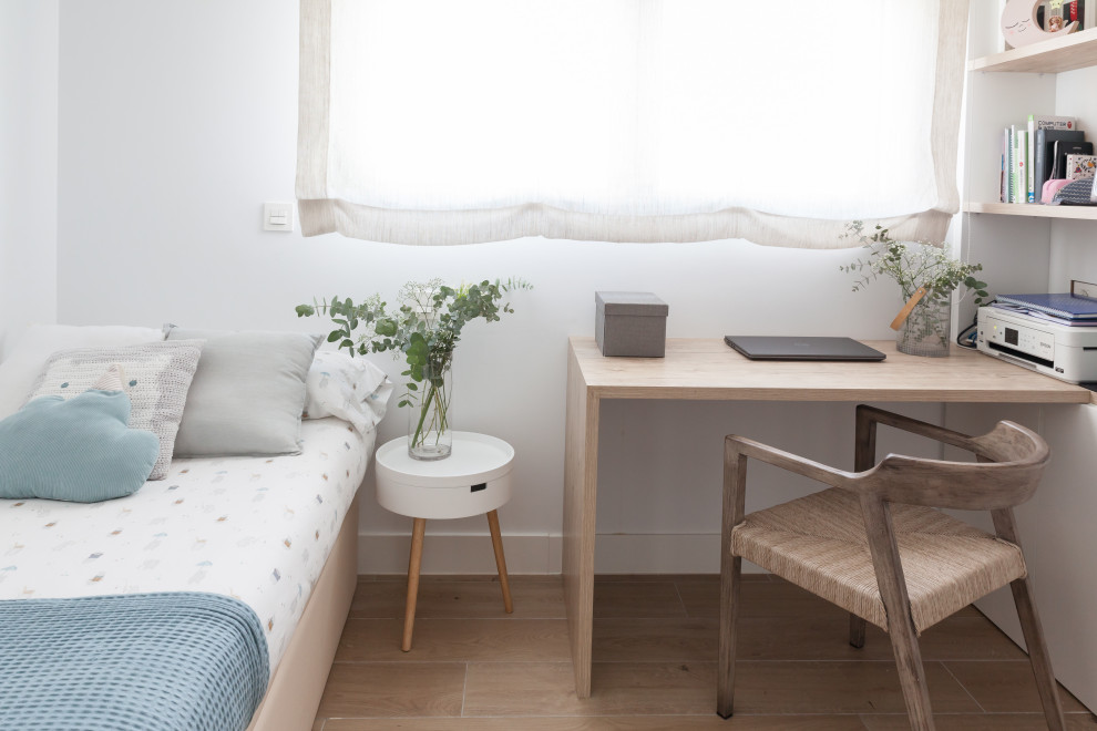 Modelo de despacho nórdico pequeño con biblioteca, paredes blancas, suelo de baldosas de cerámica, escritorio empotrado y suelo marrón