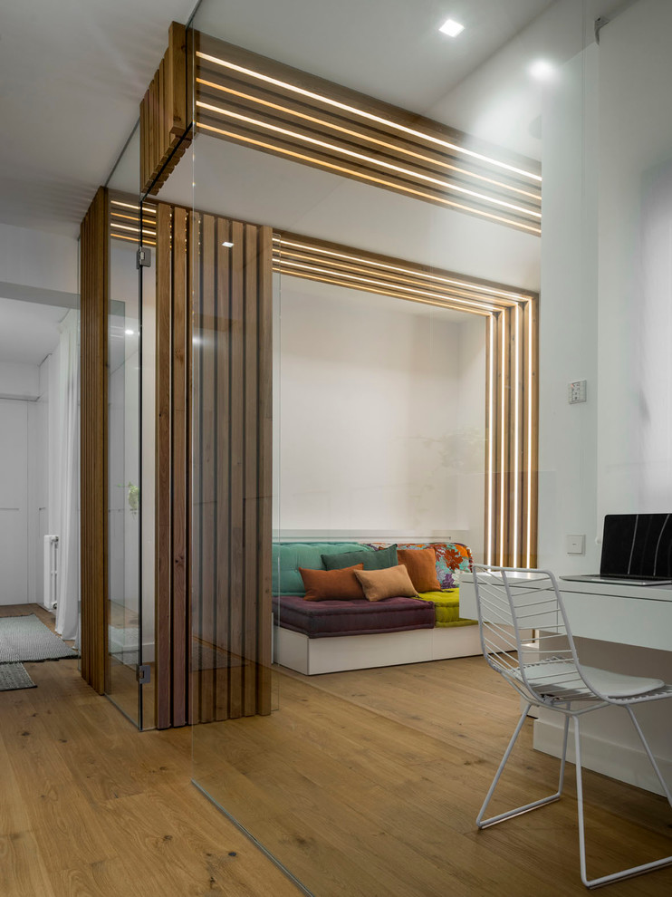 Foto de sala de manualidades contemporánea de tamaño medio con paredes blancas, suelo de madera en tonos medios y escritorio independiente
