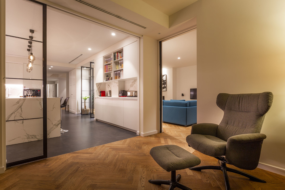Imagen de despacho actual de tamaño medio sin chimenea con paredes blancas, suelo de madera en tonos medios, escritorio empotrado y suelo marrón
