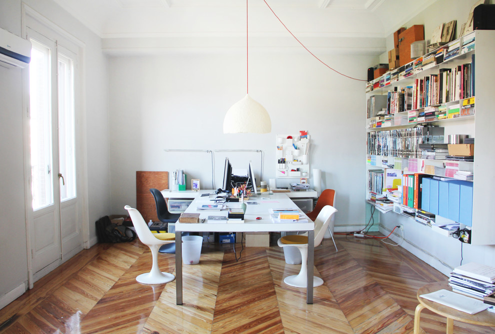 Foto de despacho actual de tamaño medio sin chimenea con paredes blancas, suelo de madera clara y escritorio independiente