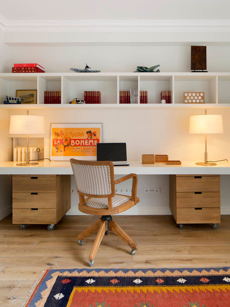Inspiration for a medium sized retro study in Barcelona with white walls, light hardwood flooring, no fireplace and a built-in desk.
