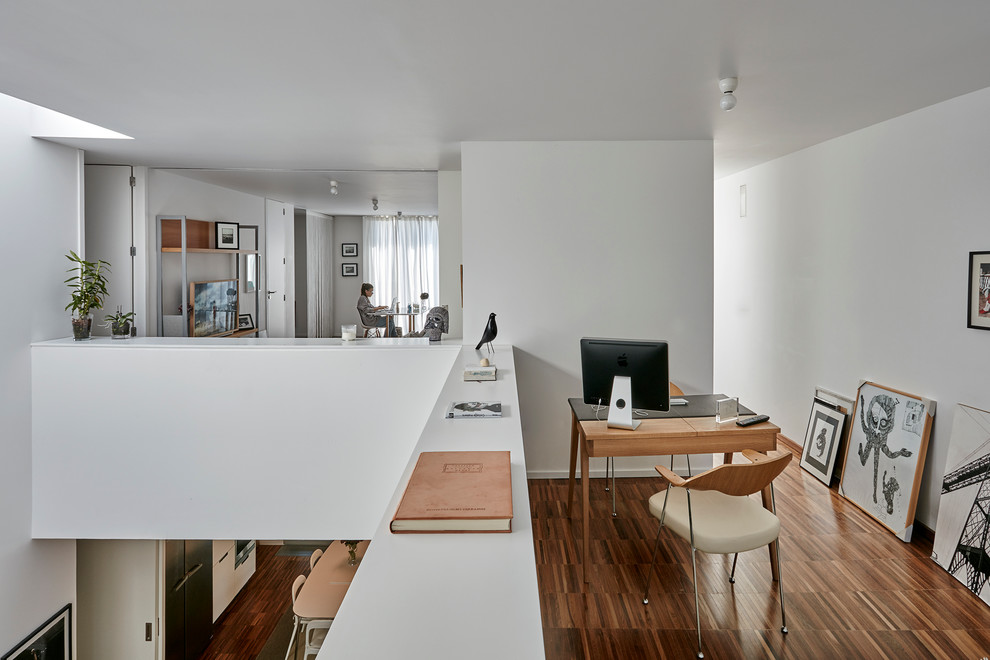 Foto de despacho actual pequeño sin chimenea con paredes blancas, suelo de madera oscura, escritorio independiente y suelo marrón