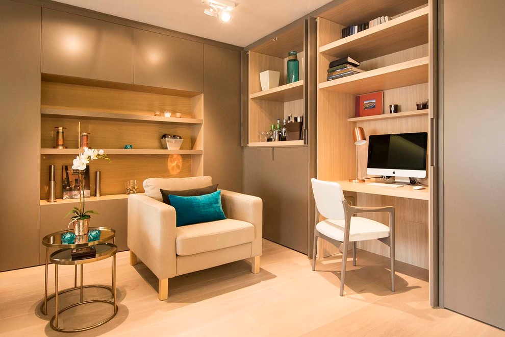 Imagen de despacho contemporáneo de tamaño medio sin chimenea con paredes beige, suelo de madera clara y escritorio empotrado