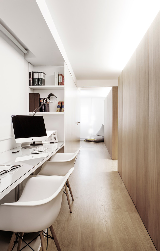 Small scandi study in Valencia with white walls, light hardwood flooring, a built-in desk and no fireplace.