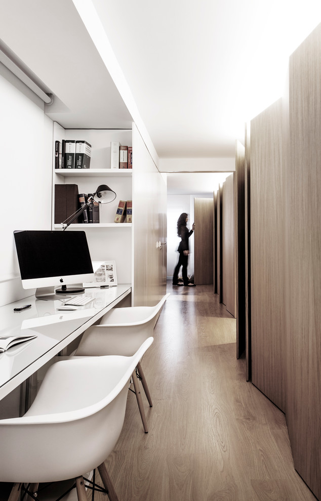 Diseño de despacho escandinavo pequeño sin chimenea con paredes blancas, suelo de madera en tonos medios y escritorio empotrado
