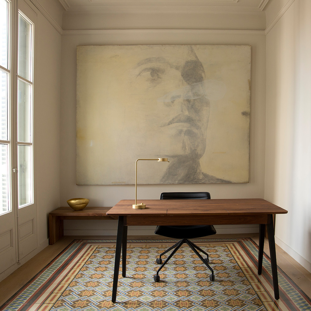 Bild på ett medelhavsstil arbetsrum, med beige väggar, ett fristående skrivbord och flerfärgat golv