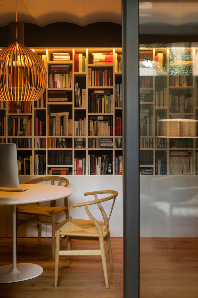 Foto di uno studio nordico di medie dimensioni con libreria, pareti bianche, pavimento in legno massello medio, nessun camino e scrivania autoportante