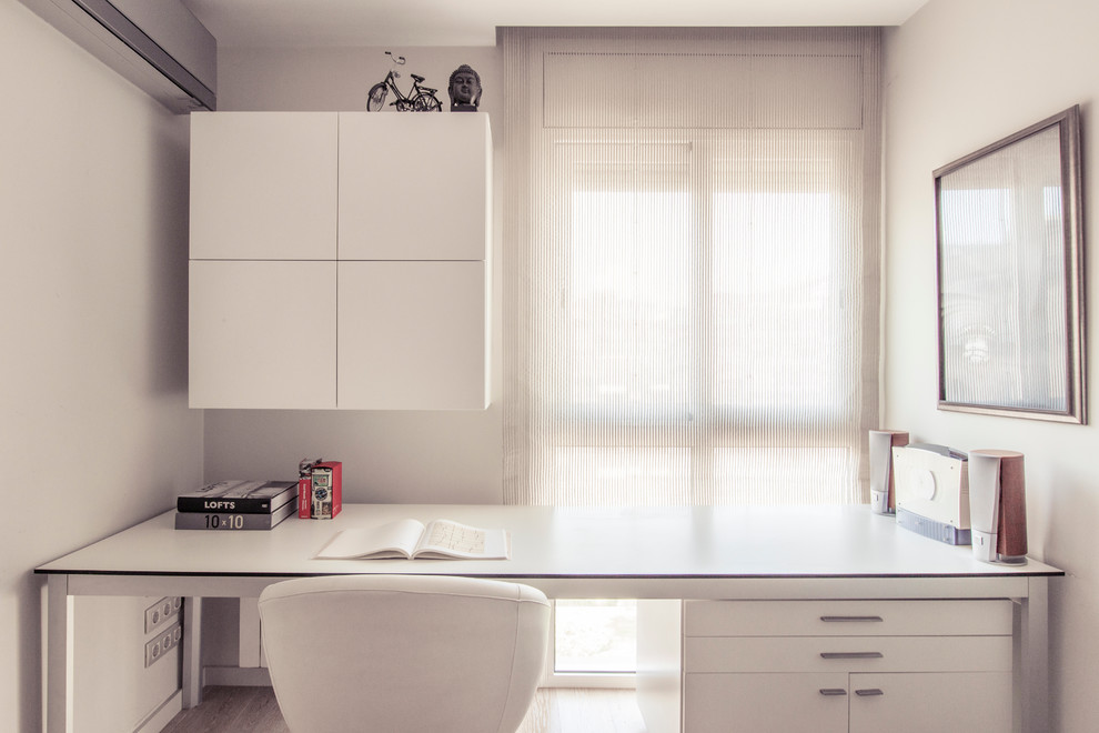 Kleines Modernes Arbeitszimmer ohne Kamin mit Arbeitsplatz, weißer Wandfarbe und Einbau-Schreibtisch in Barcelona
