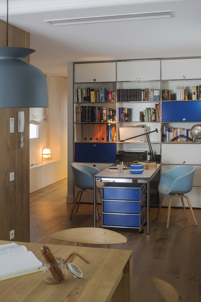 Mittelgroßes Skandinavisches Arbeitszimmer ohne Kamin mit Studio, weißer Wandfarbe, braunem Holzboden und freistehendem Schreibtisch in Sonstige