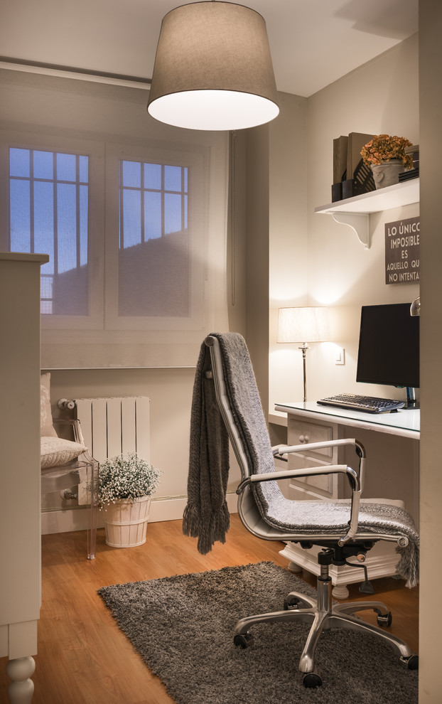 マドリードにある小さなトランジショナルスタイルのおしゃれな書斎 (ベージュの壁、無垢フローリング、暖炉なし、造り付け机、茶色い床) の写真