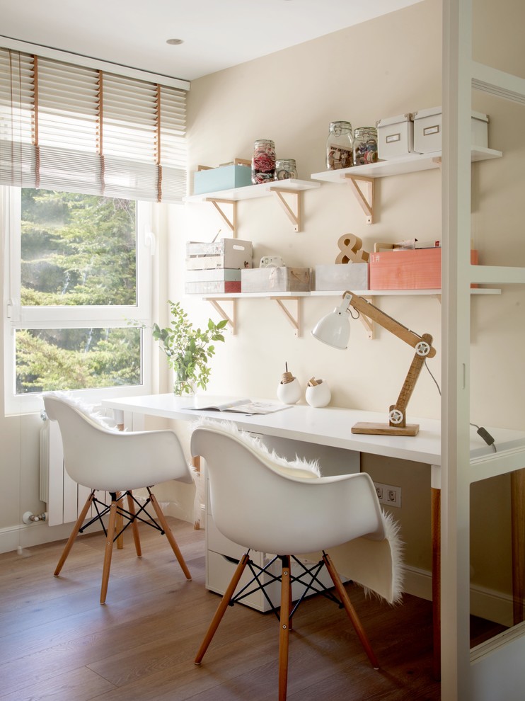 Modelo de despacho tradicional renovado de tamaño medio sin chimenea con paredes beige, suelo de madera en tonos medios, suelo marrón y escritorio independiente
