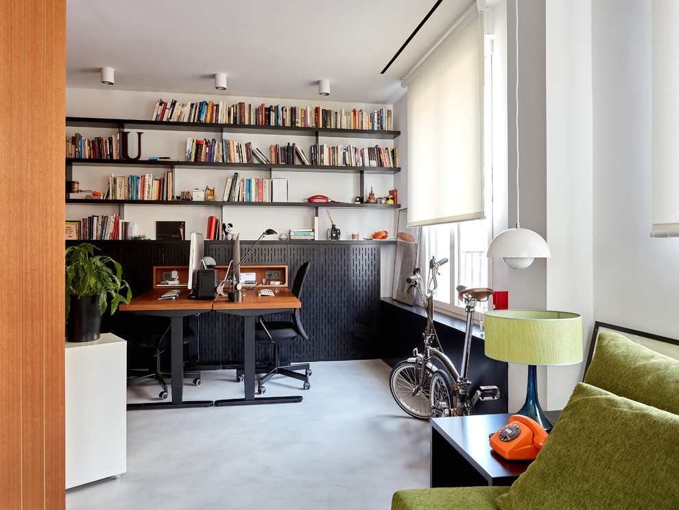 Idee per un grande studio minimal con libreria, pareti bianche, pavimento in cemento, nessun camino, scrivania autoportante e pavimento grigio