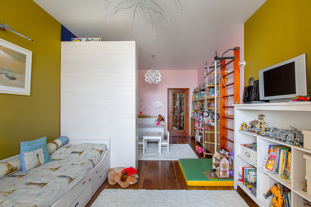 Modelo de dormitorio infantil de 4 a 10 años actual con paredes multicolor y suelo de madera en tonos medios