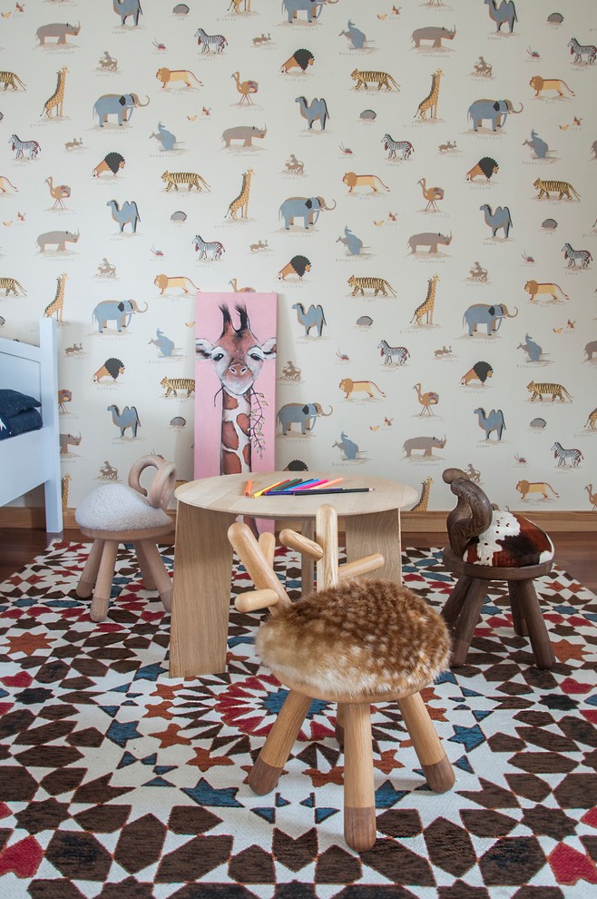 Cette image montre une chambre d'enfant de 4 à 10 ans nordique de taille moyenne avec un mur multicolore, un sol en bois brun et un sol marron.