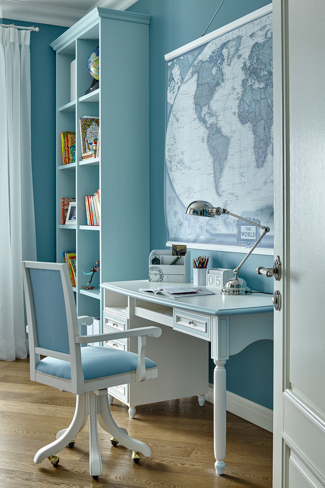 Ejemplo de habitación infantil unisex tradicional con escritorio, paredes azules y suelo de madera en tonos medios