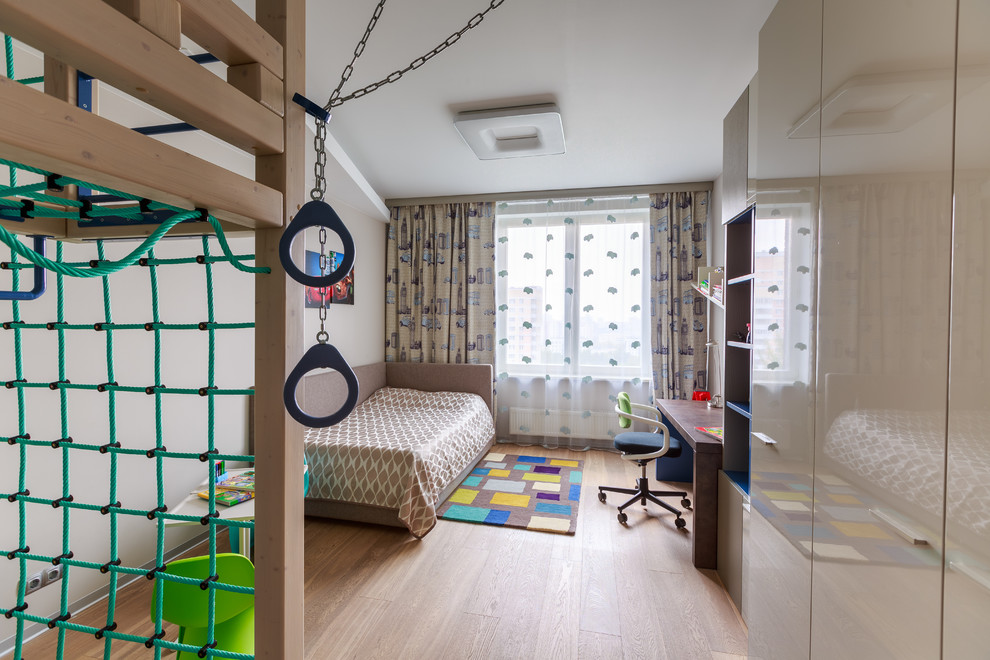 На фото: детская в современном стиле с спальным местом, белыми стенами и паркетным полом среднего тона для ребенка от 4 до 10 лет, мальчика