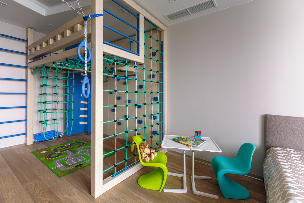 Example of a trendy boy medium tone wood floor kids' room design in Moscow with beige walls