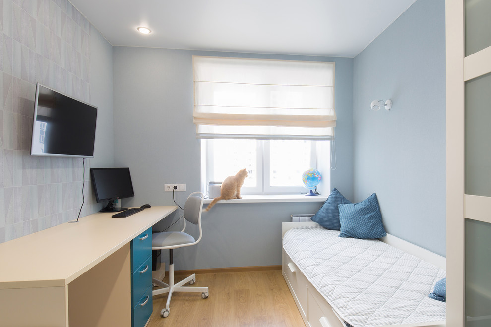 Immagine di una piccola cameretta per bambini contemporanea con pareti blu, pavimento in laminato e pavimento beige