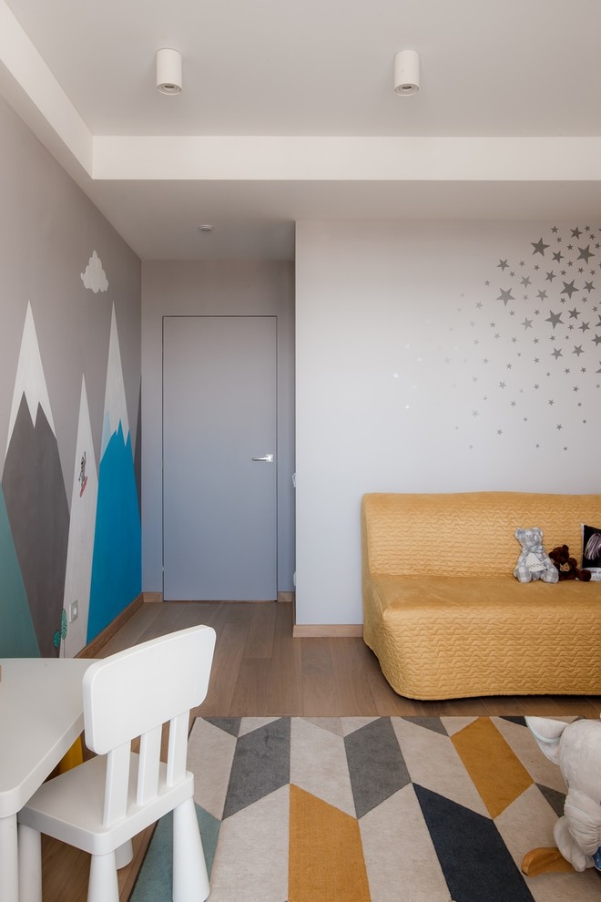 Cette photo montre une petite chambre d'enfant de 1 à 3 ans tendance avec un mur gris, parquet clair et un sol beige.