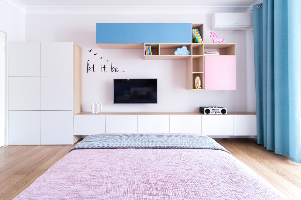Ispirazione per una grande cameretta per bambini design con pareti rosa, pavimento in legno massello medio e pavimento marrone