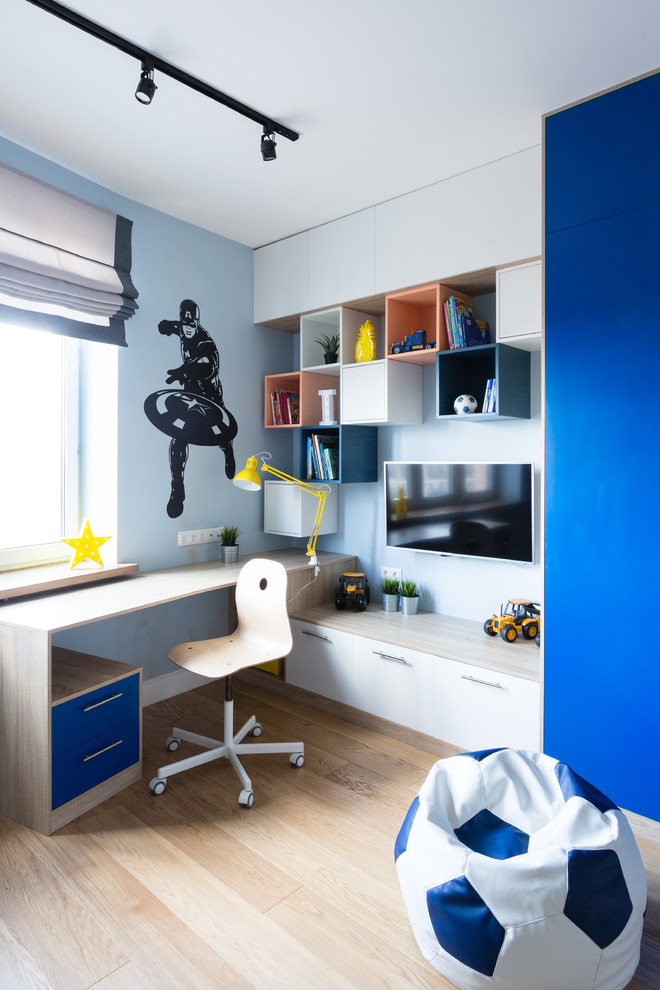 Immagine di una grande cameretta per bambini da 4 a 10 anni minimal con pareti blu, pavimento in legno massello medio e pavimento beige
