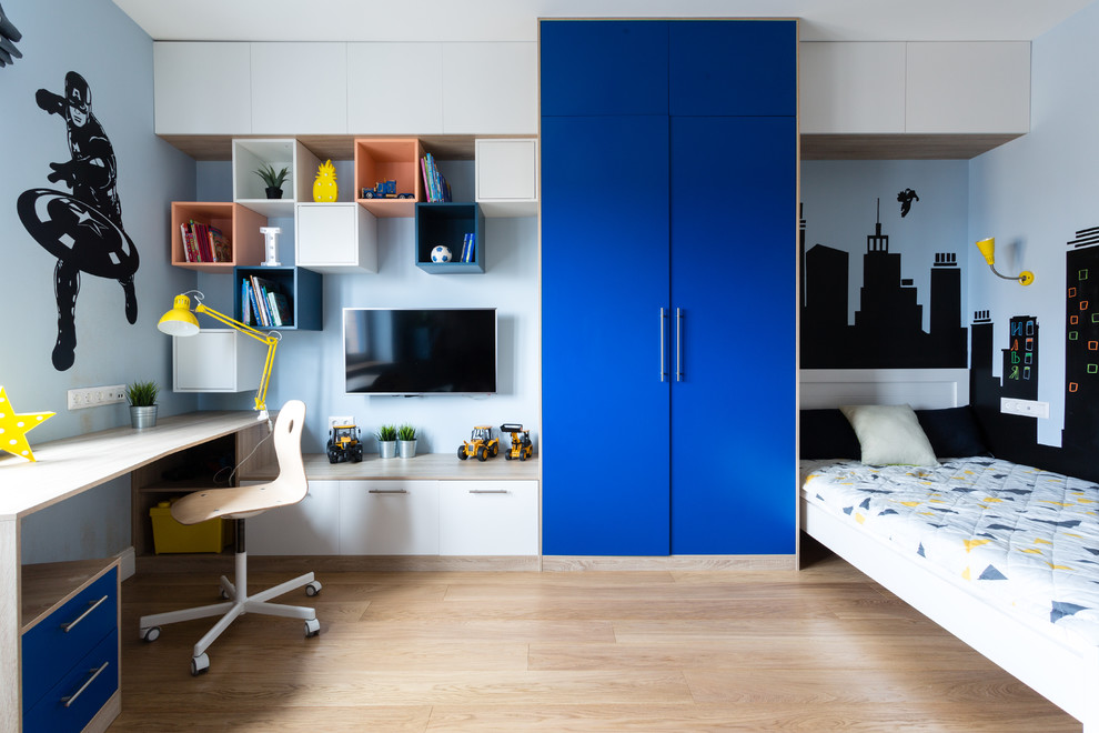 Exempel på ett stort modernt pojkrum kombinerat med skrivbord och för 4-10-åringar, med blå väggar, mellanmörkt trägolv och brunt golv