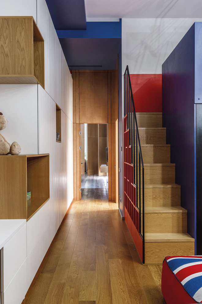 Idéer för att renovera ett mellanstort funkis barnrum kombinerat med lekrum, med blå väggar, mellanmörkt trägolv och orange golv