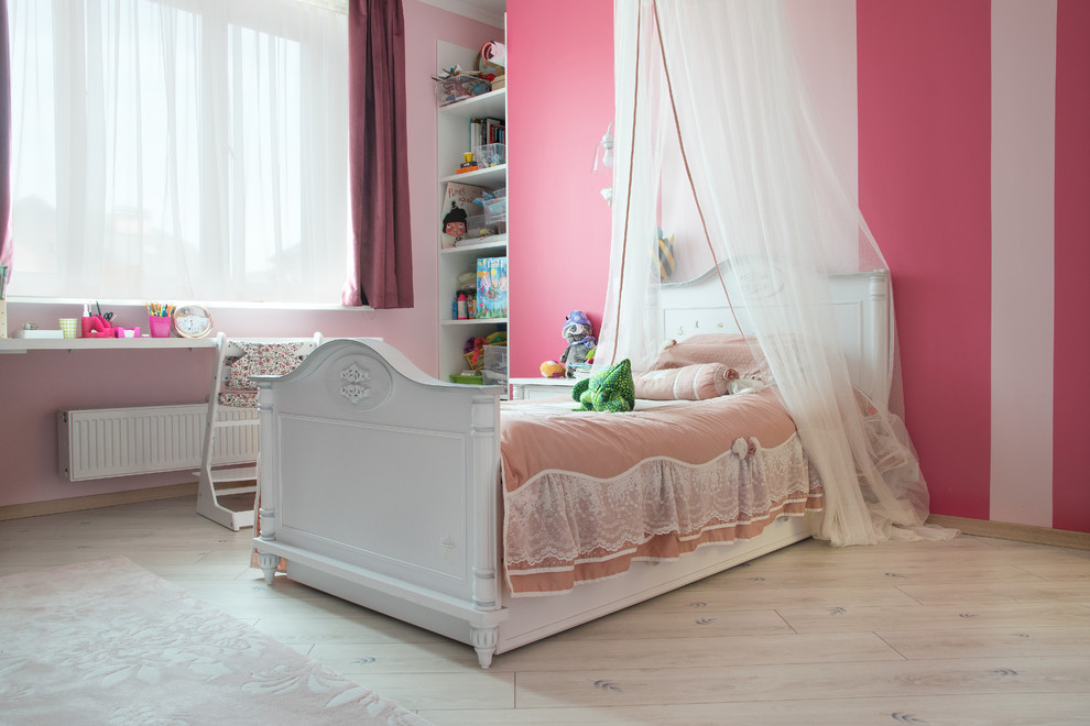 Foto di una cameretta per bambini da 4 a 10 anni contemporanea di medie dimensioni con pareti rosa, pavimento in laminato e pavimento beige