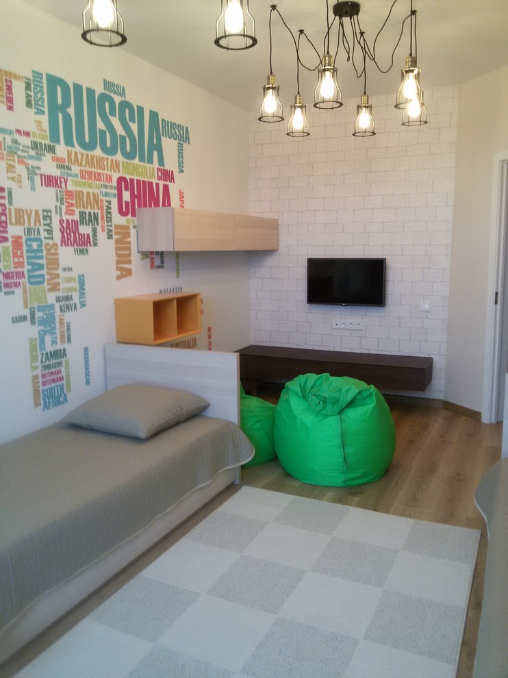 Immagine di una piccola cameretta per bambini da 4 a 10 anni contemporanea con pareti beige, pavimento in laminato e pavimento marrone