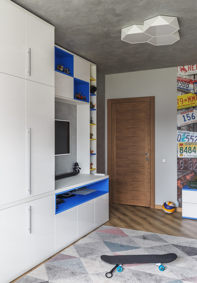 This is an example of a medium sized contemporary teen’s room for boys in Moscow with white walls, carpet and multi-coloured floors.