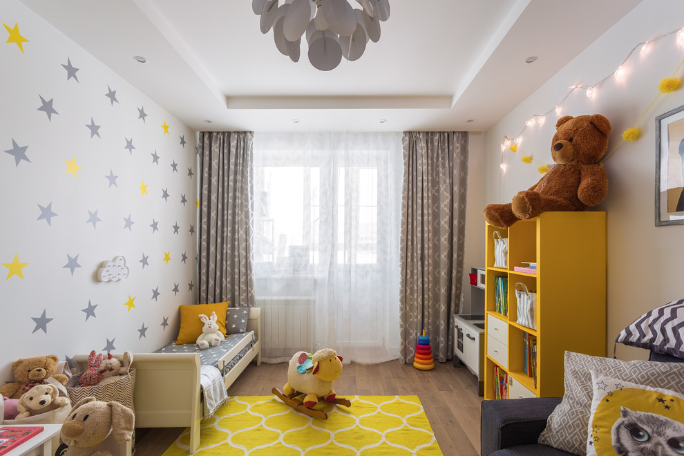Cette photo montre une grande chambre d'enfant de 1 à 3 ans tendance avec un mur blanc, parquet clair et un sol marron.