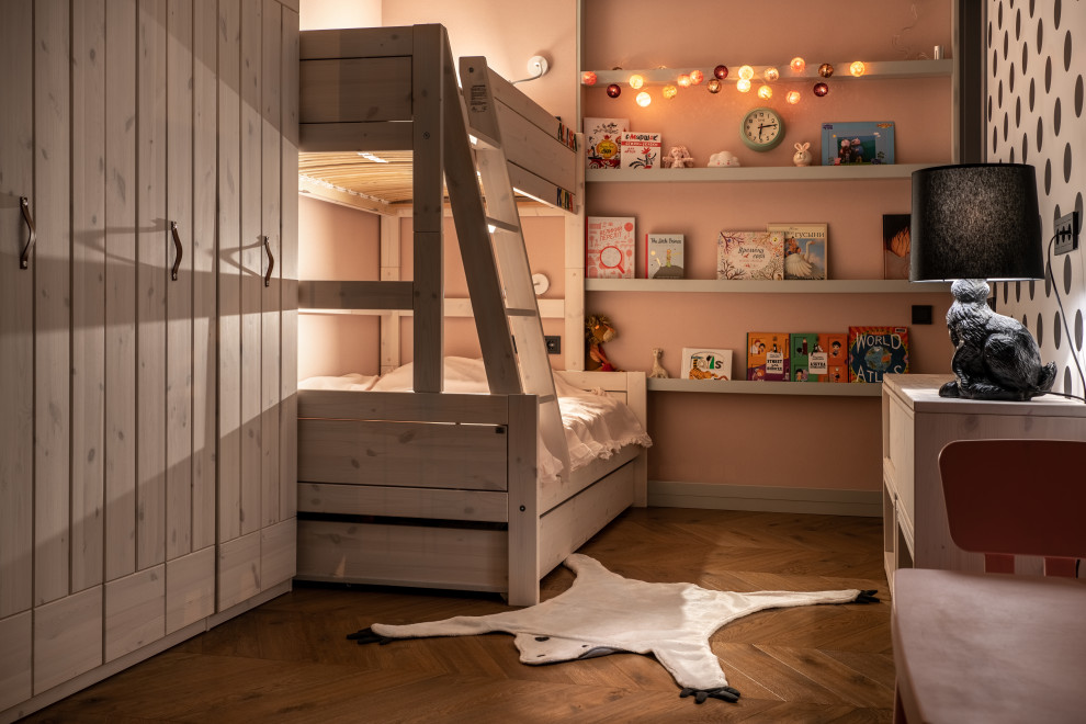 Cette photo montre une grande chambre d'enfant de 4 à 10 ans tendance avec un mur rose, un sol en bois brun, un sol marron et du papier peint.